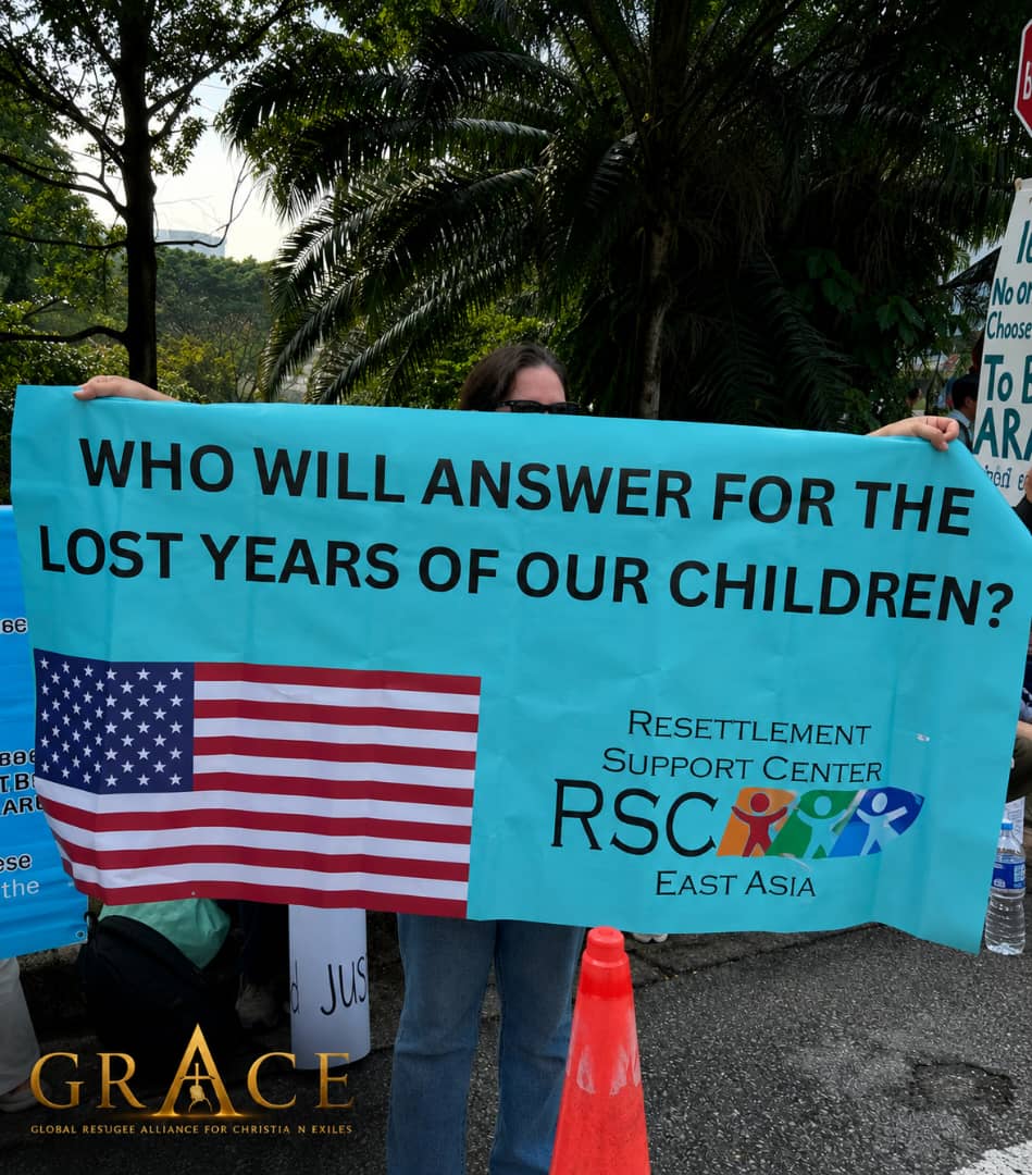 A refugee advocacy gathering in Malaysia where a placard asks who will answer for the lost years of refugee children